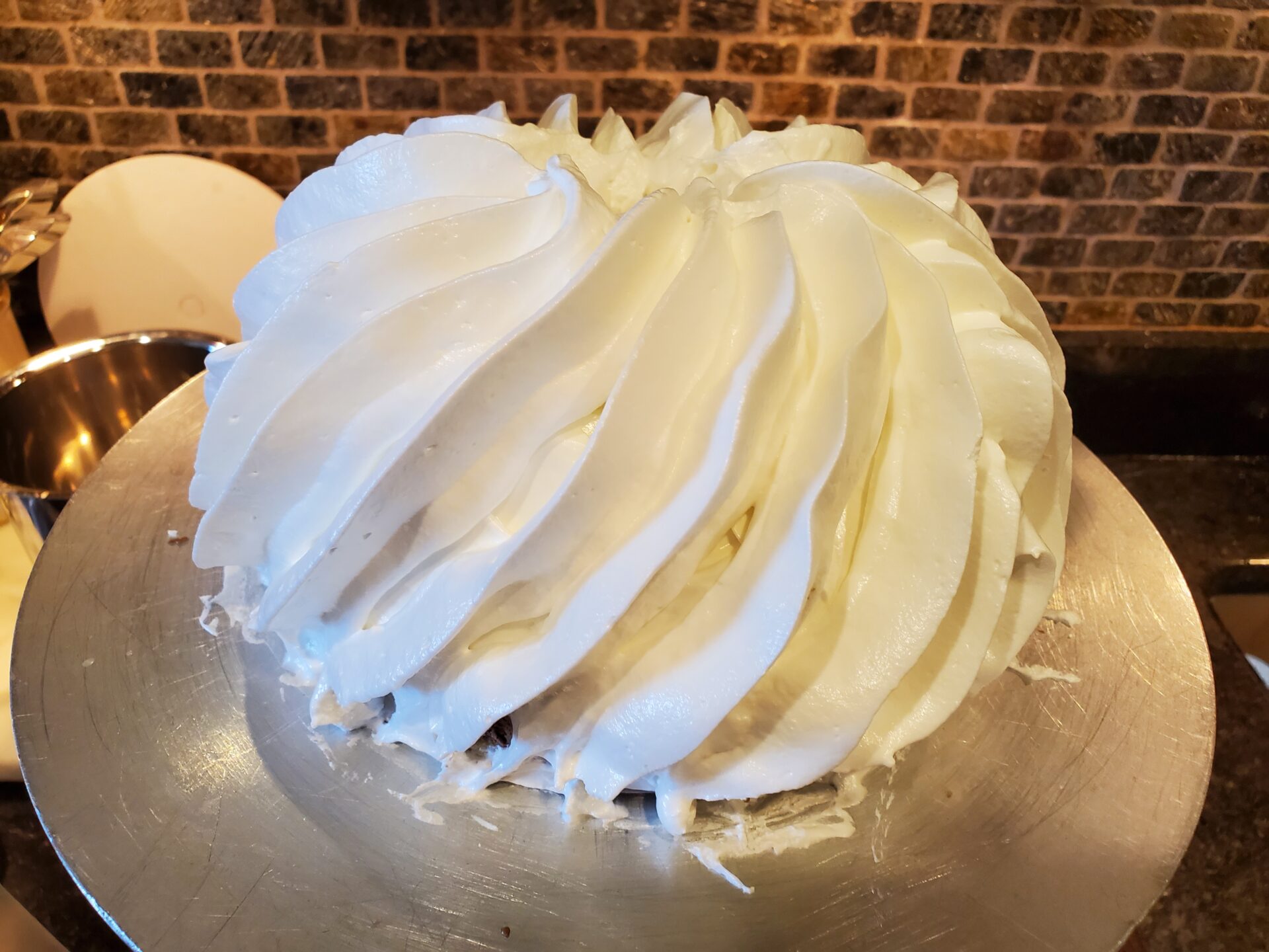 A cake with white frosting on top of a table.