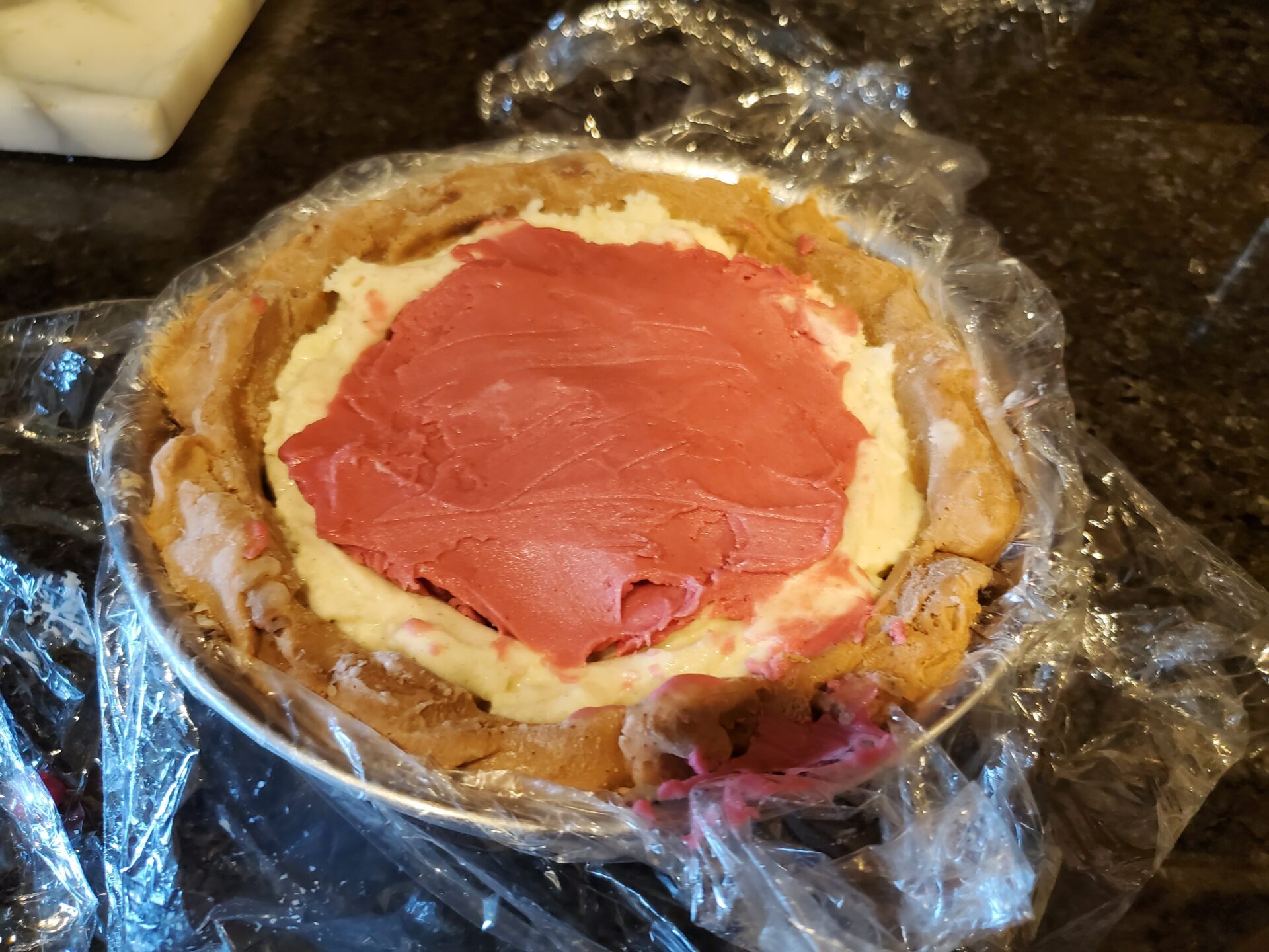 A pie crust with some red frosting on it