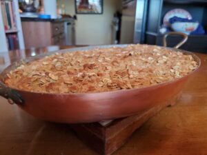 A wooden bowl with some food on top of it