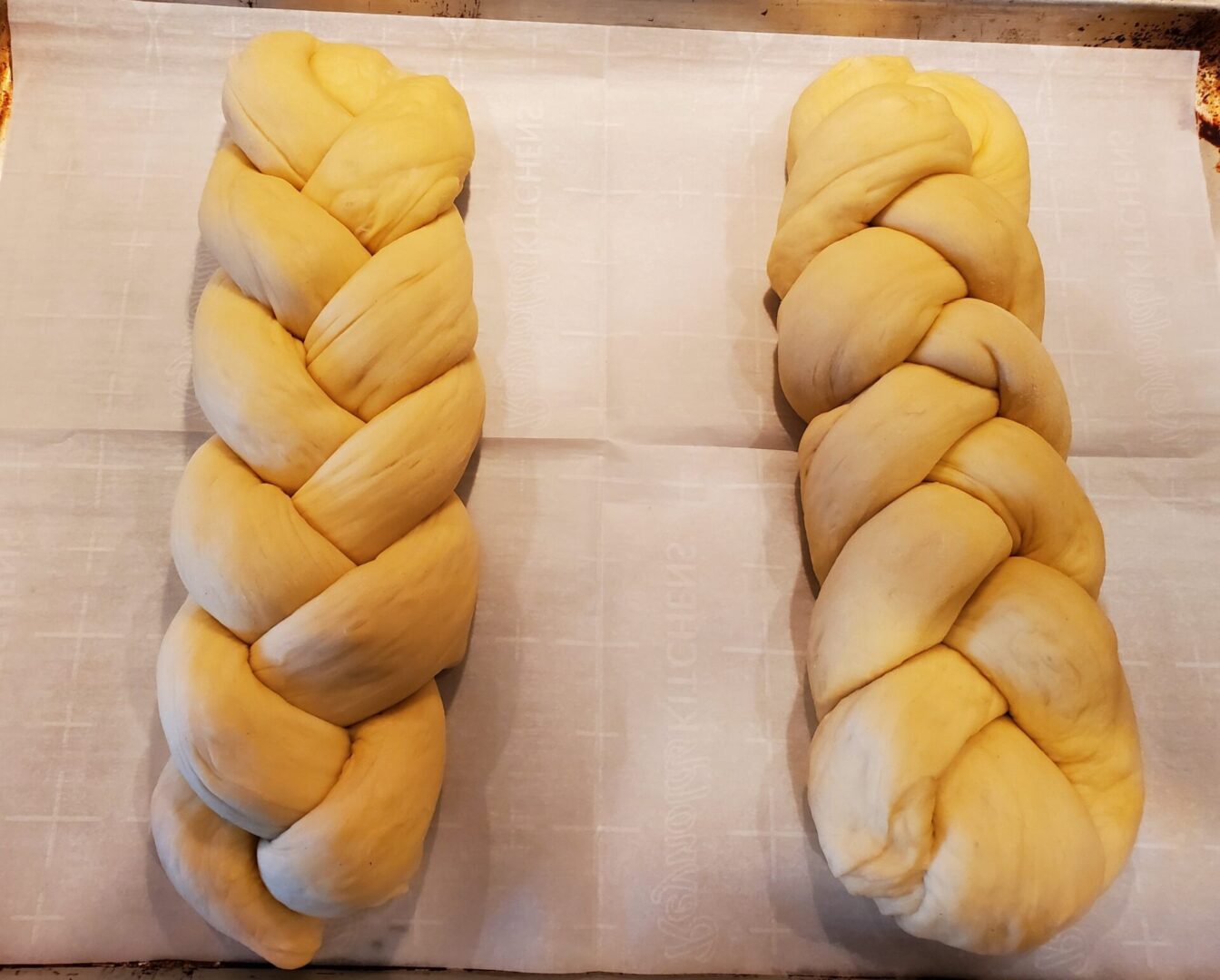 Two loaves of bread on a white cloth.