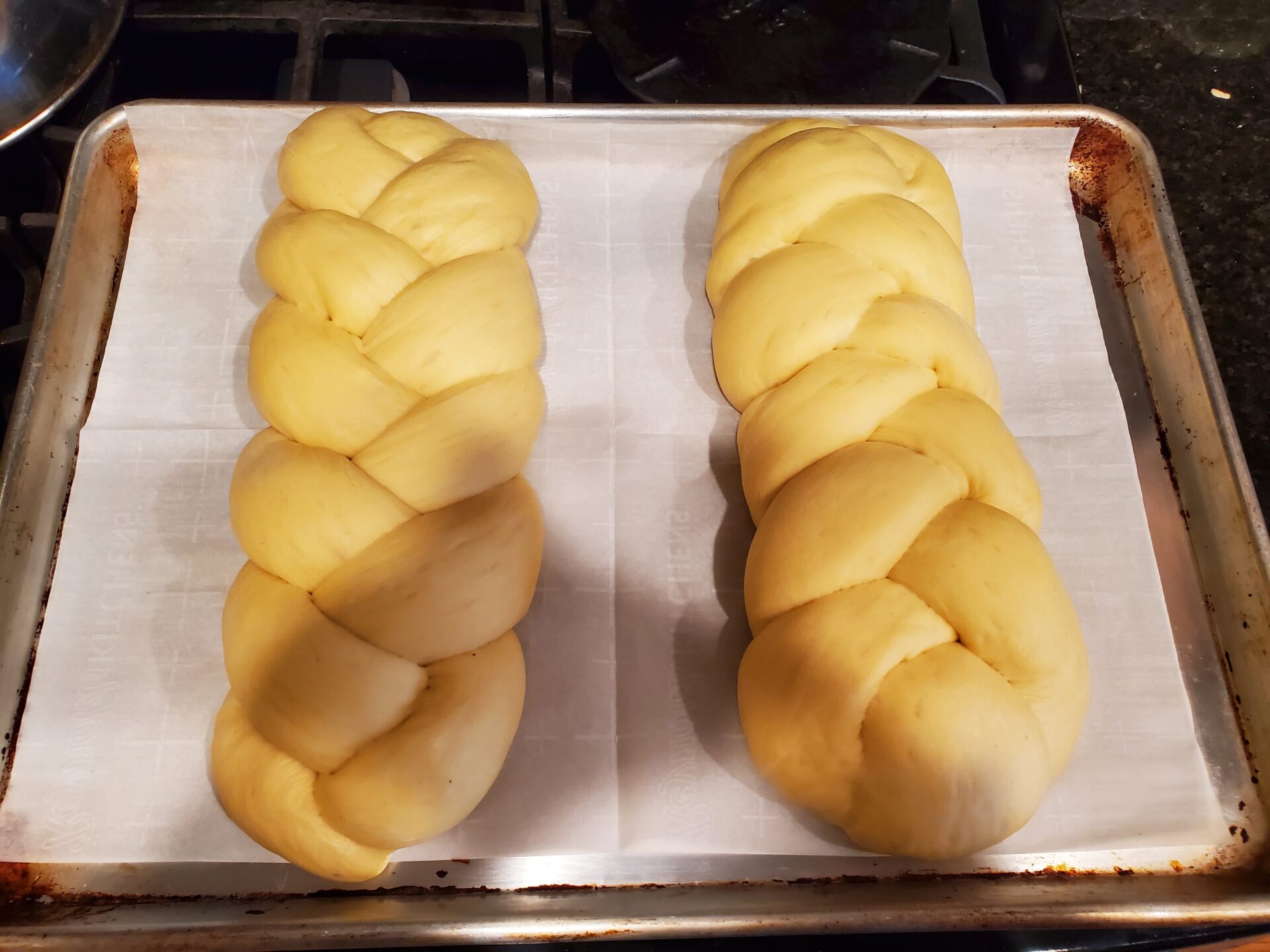 Two rolls of bread on a baking sheet.