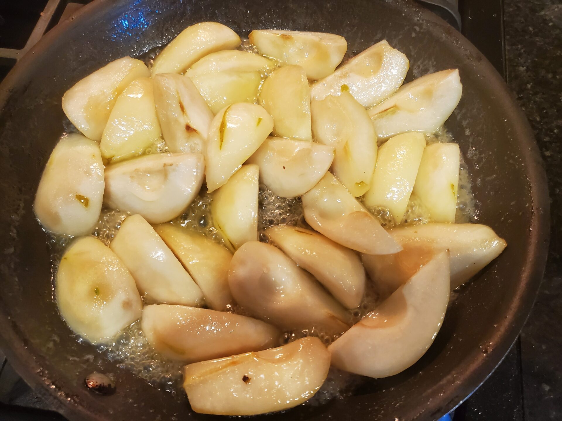 A pan with apples in it cooking on the stove.