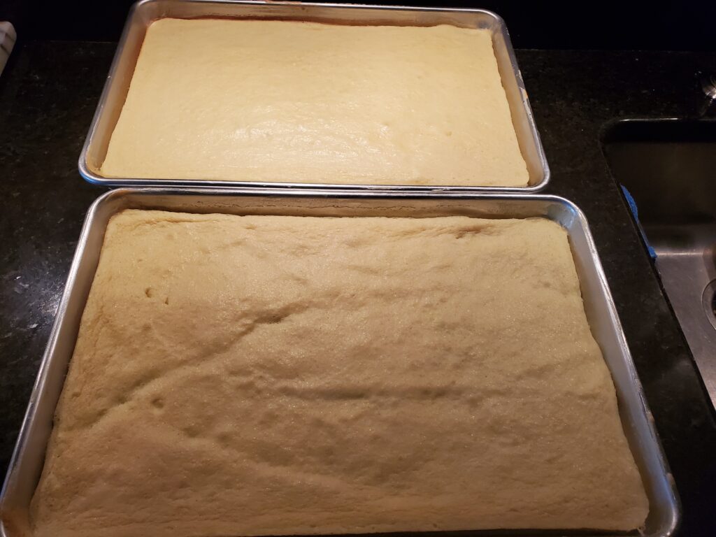 Two pans of dough on a table.