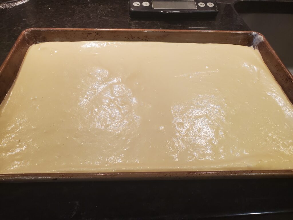 A tray of dough is on the counter.