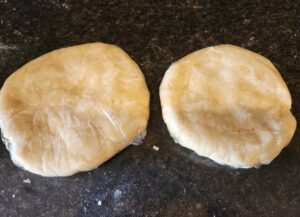 Two dough balls on a counter top.