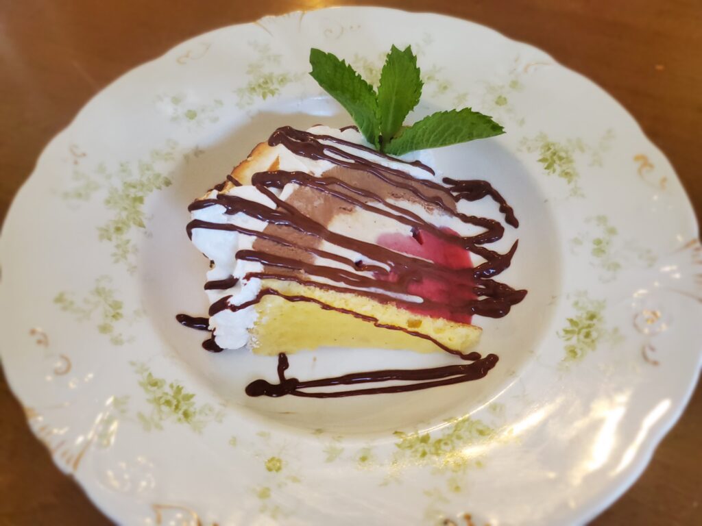 A piece of cake with chocolate and strawberries on top.