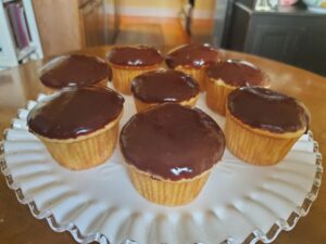 A plate of chocolate cupcakes on top of a table.