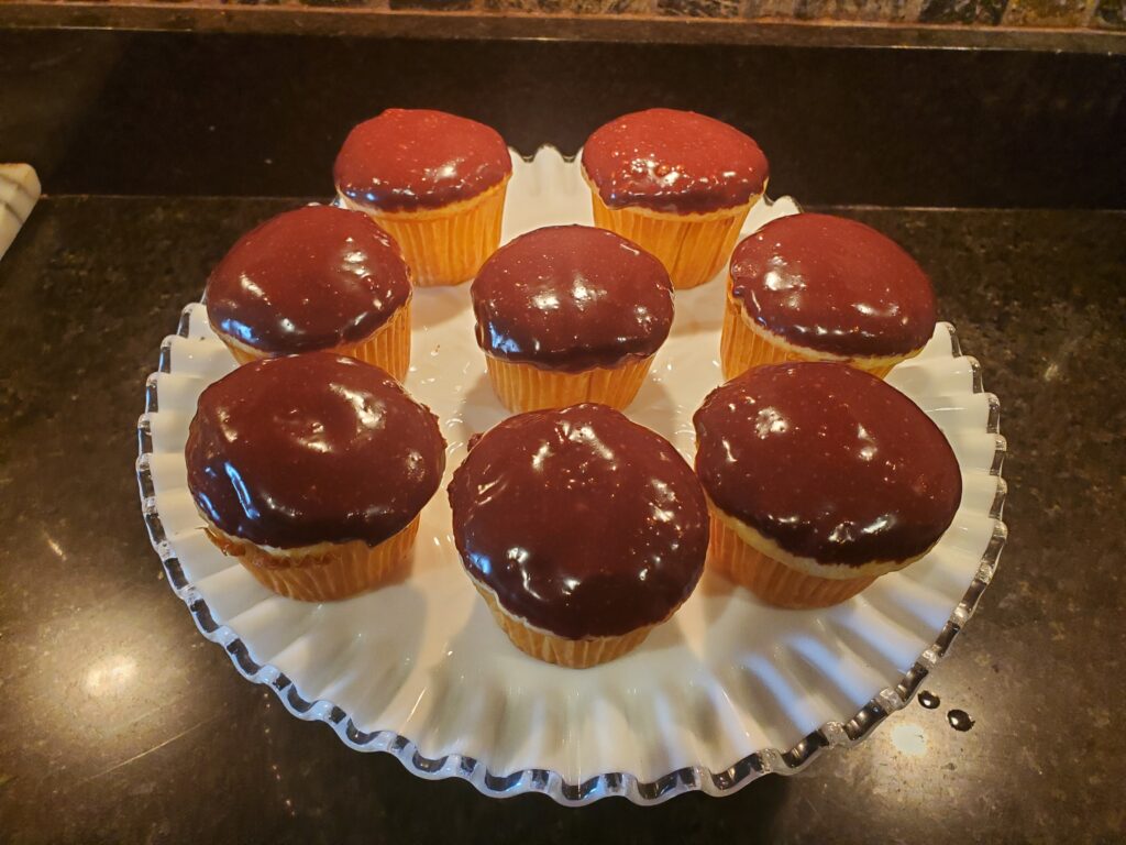 A plate of chocolate cupcakes on top of a table.