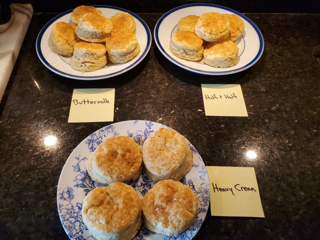 A table topped with plates of biscuits and two plates.