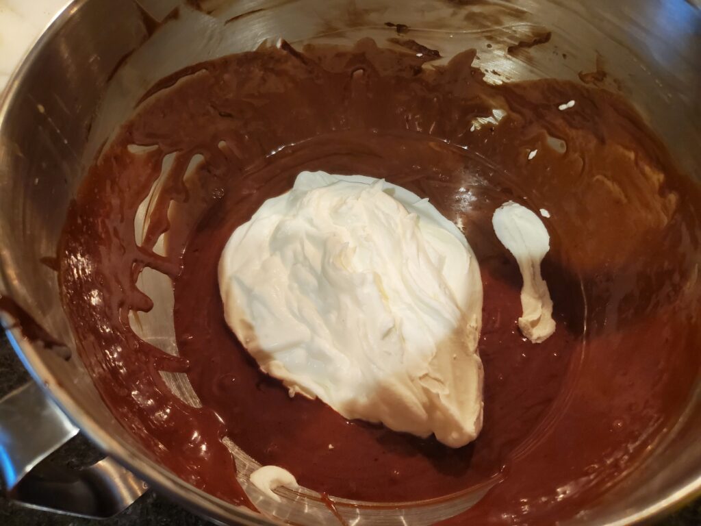 A bowl of chocolate and whipped cream in it.