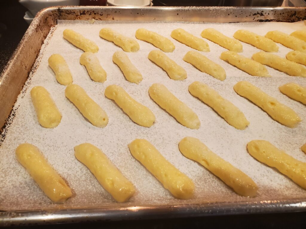 A tray of baked pastry sticks on top of parchment paper.