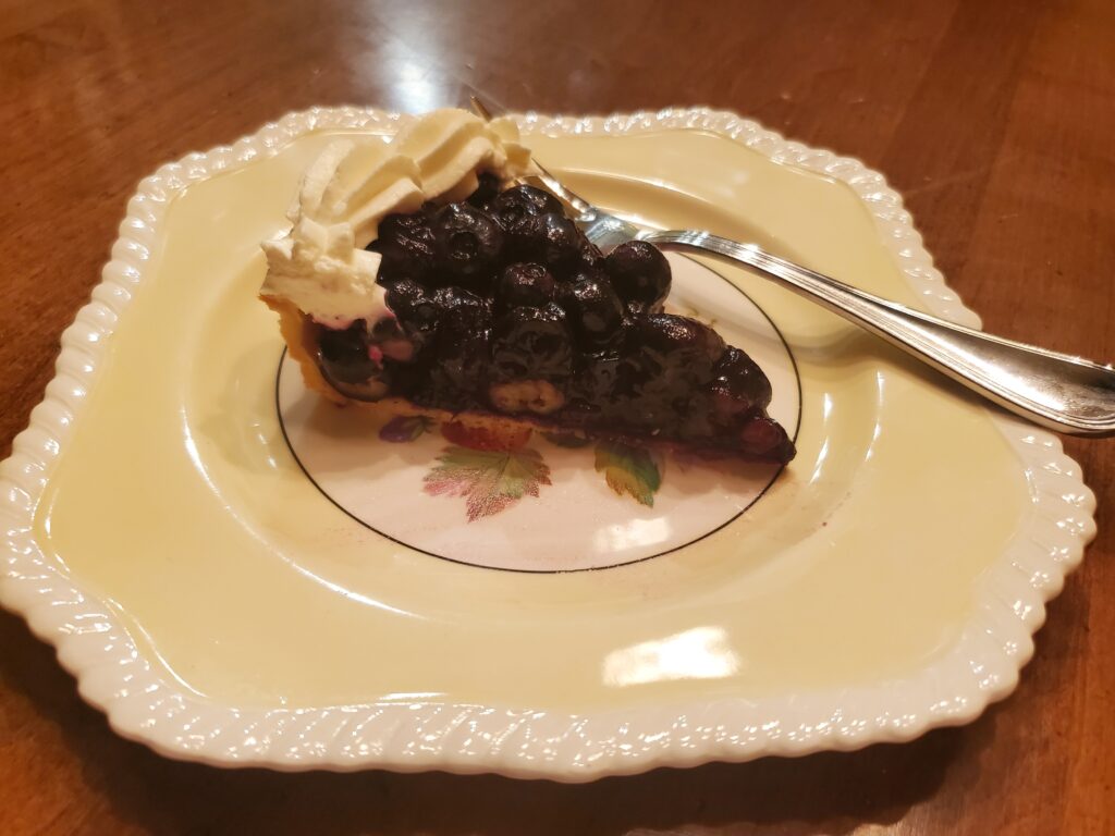 A piece of pie on a plate with a fork.