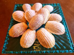 A plate of madeleines on top of a table.