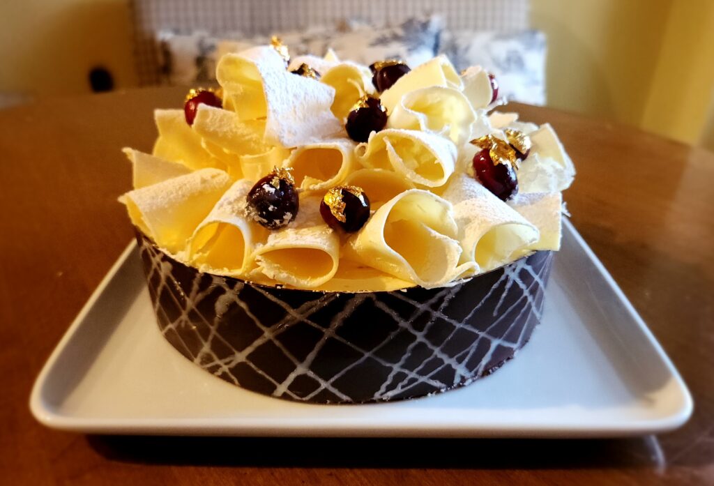 A cake with white frosting and fruit on top.