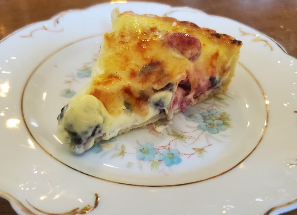 A piece of quiche on a plate with flowers.