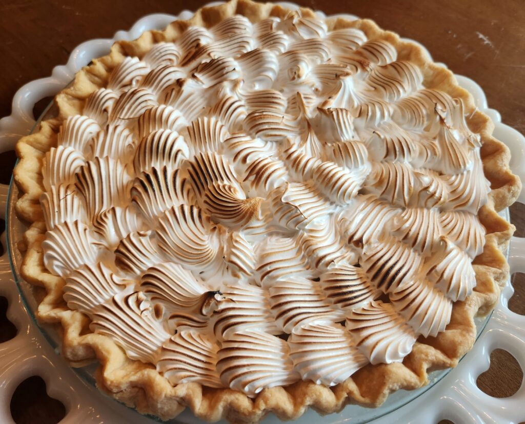 A pie with whipped cream on top of it.