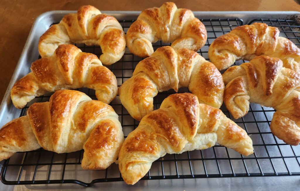 closeup croissants resting on wire rack