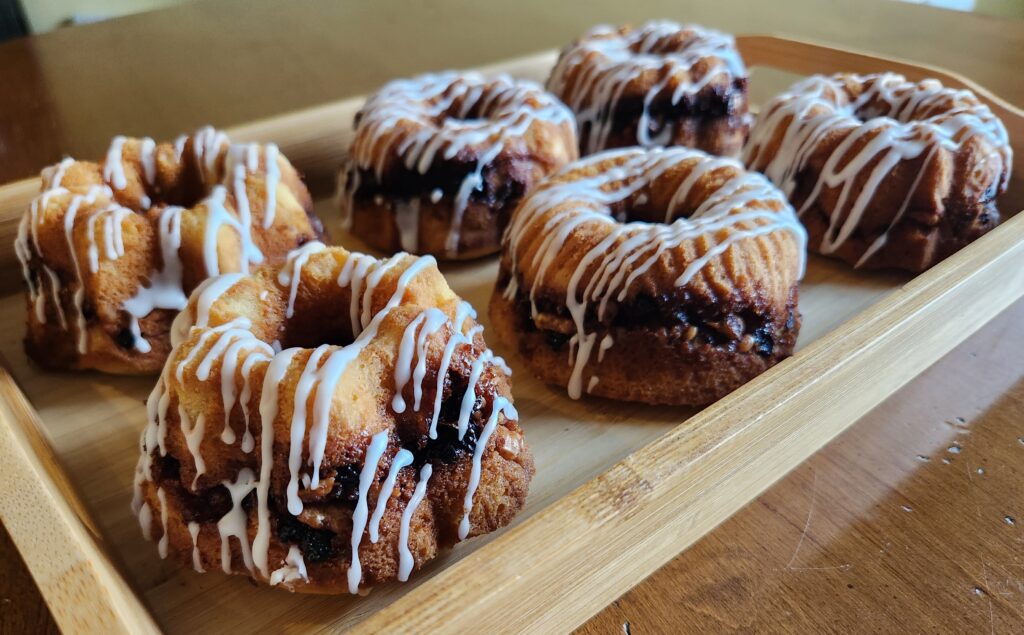 A tray of blueberry bundt cakes on a wooden table.