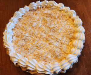 A coconut pie with whipped cream on top.