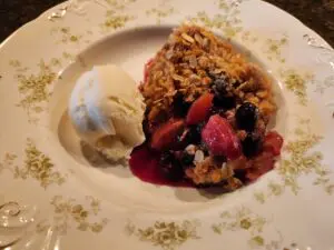 A plate with berries and ice cream on it.