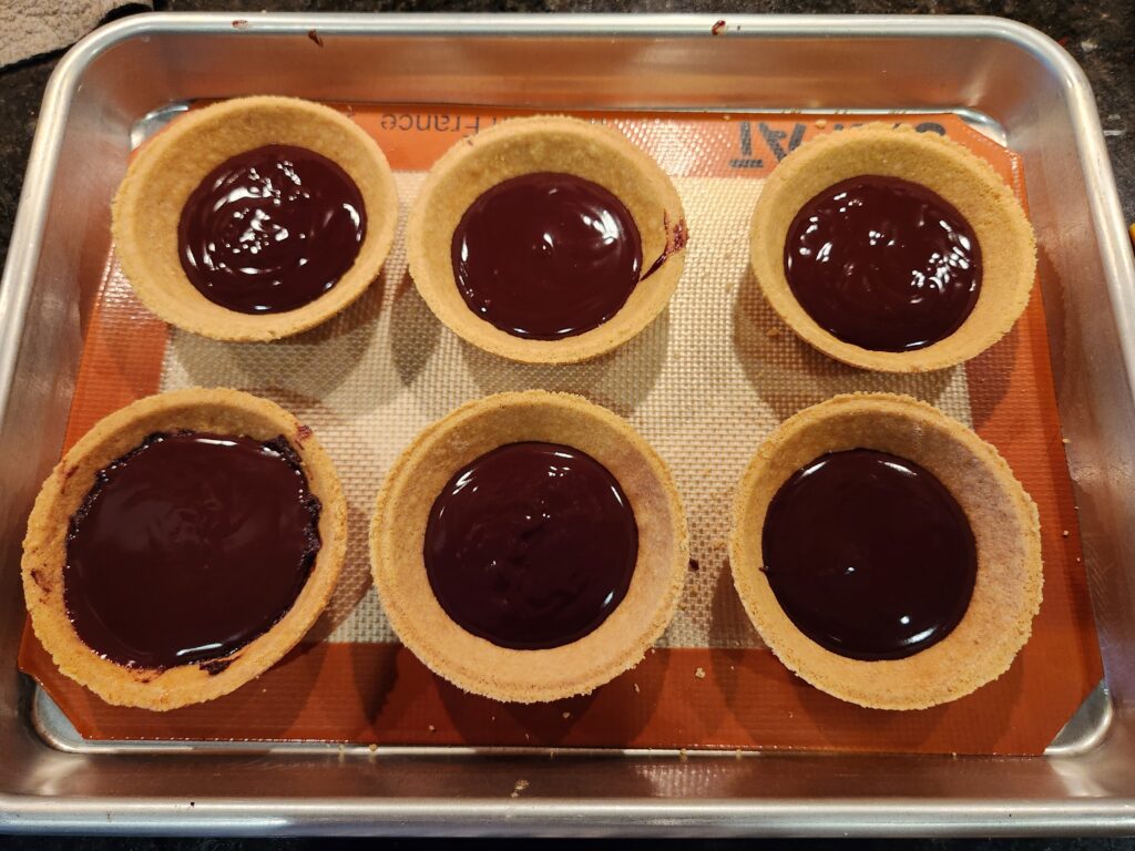 A tray of chocolate pies sitting on top of a table.