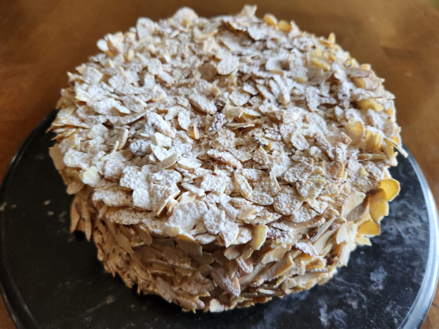 The Friday Baking Project is a blog featuring a delicious cake recipe topped with almonds and powdered sugar.