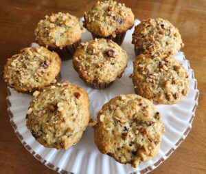 A plate of muffins on a wooden table.