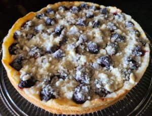 A blueberry crumb cake on a glass plate.