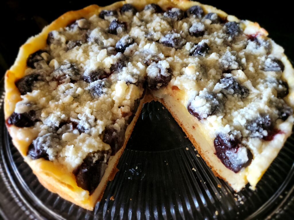 A pie with blueberries and white chocolate on top.