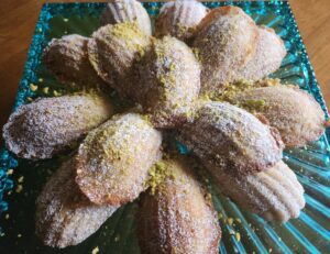 A plate topped with pastries covered in powdered sugar.