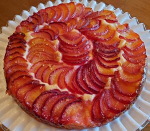 A peach tart on a glass plate.