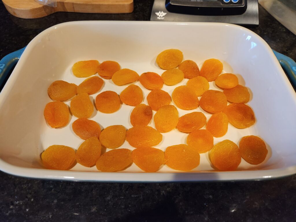 A white dish with some sliced up apricots in it