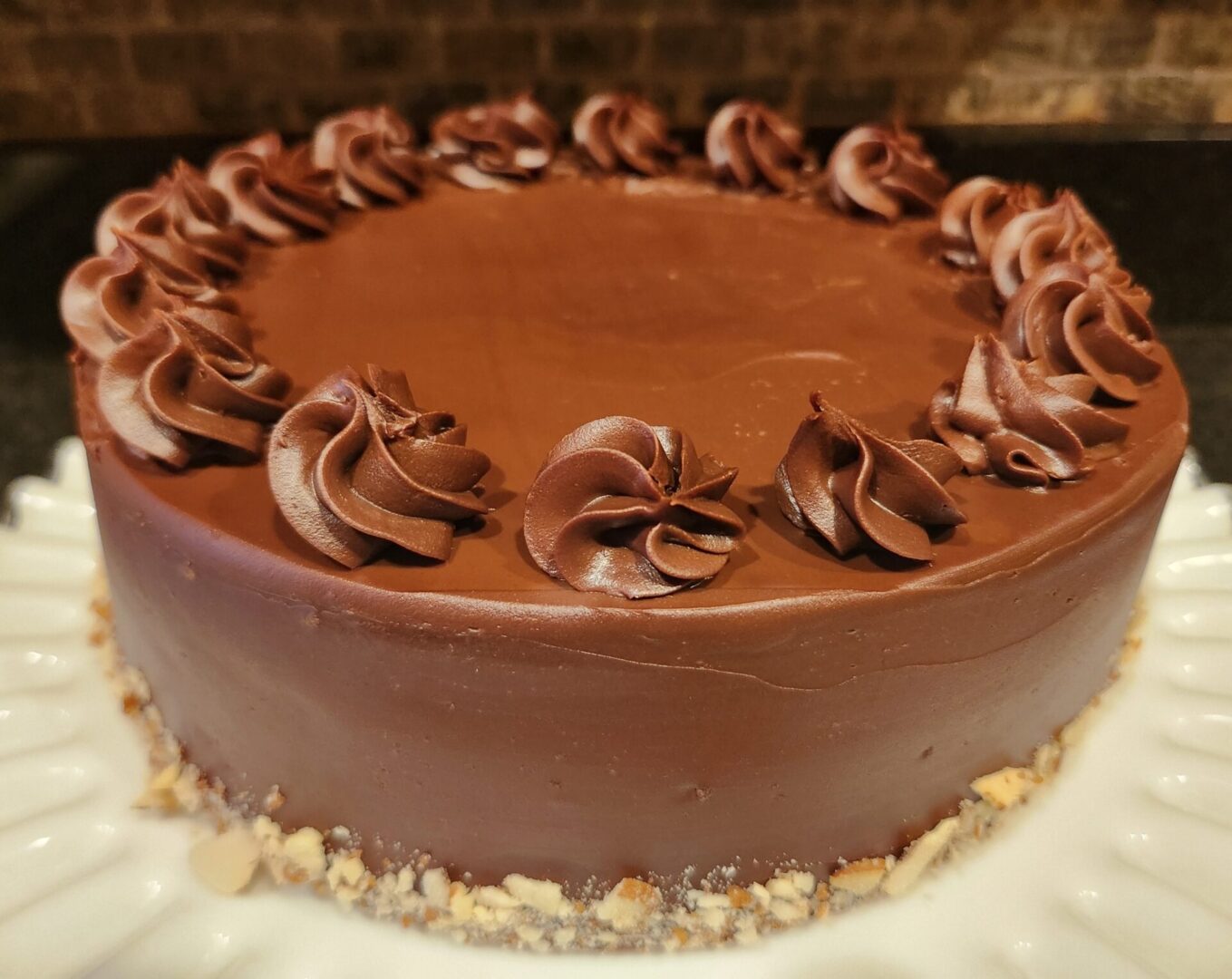 Chocolate cake with swirled frosting rosettes on top, displayed on a white plate as part of The Friday Baking Project, featuring a crumbly base.