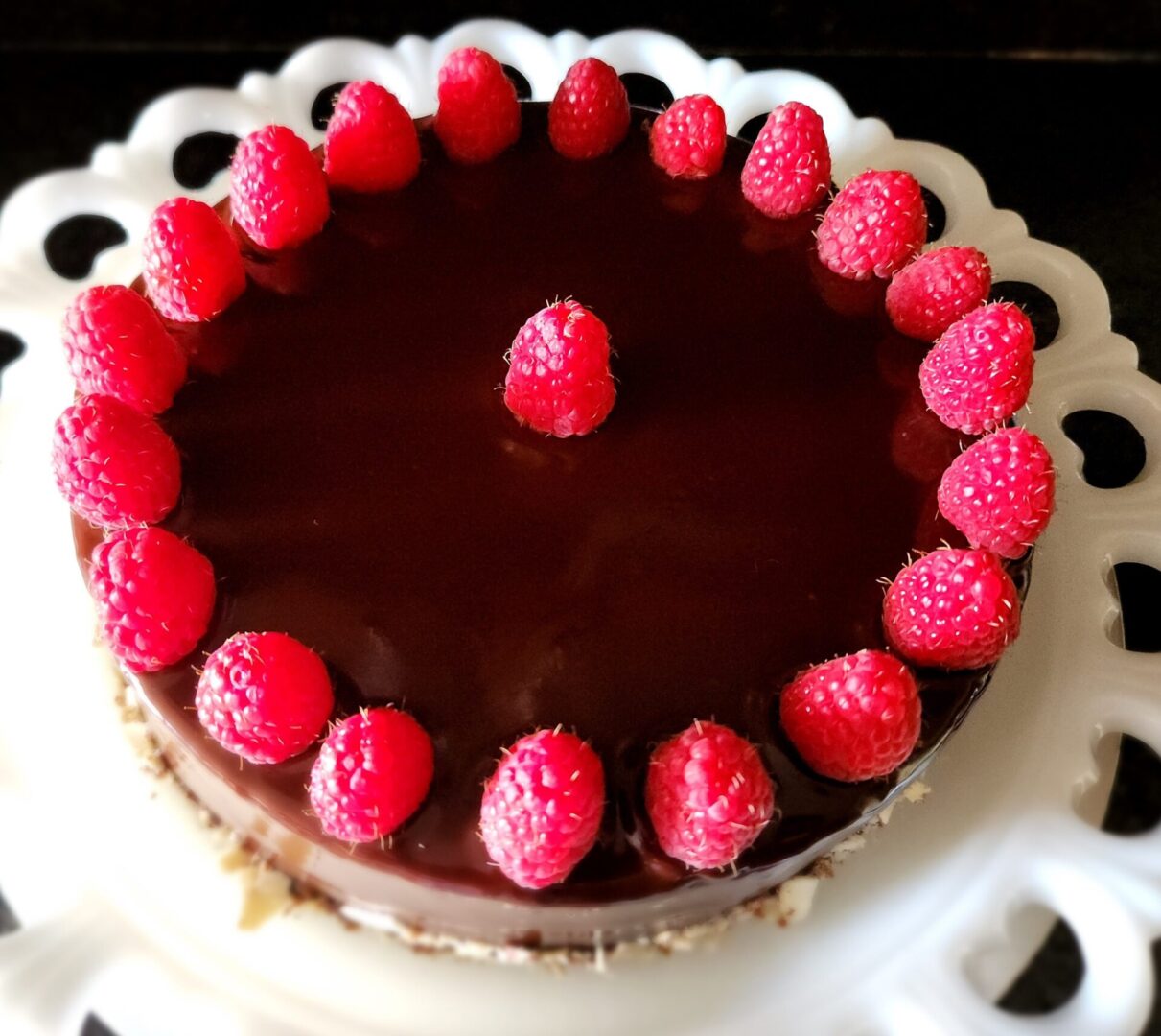 A chocolate cake with raspberries on top of it.