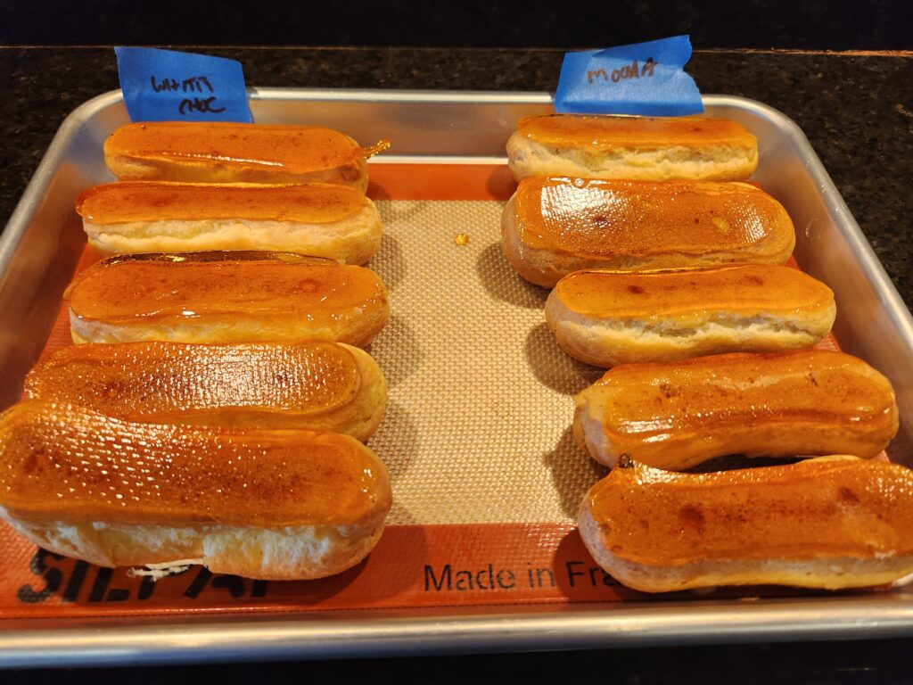 A tray of hot dogs on buns with blue labels.