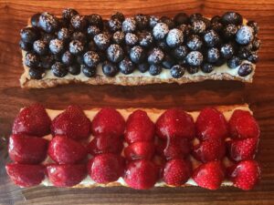 Blueberry and strawberry pastry on wood board.