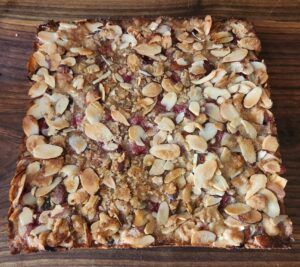 Almond-topped baked goods on wood.