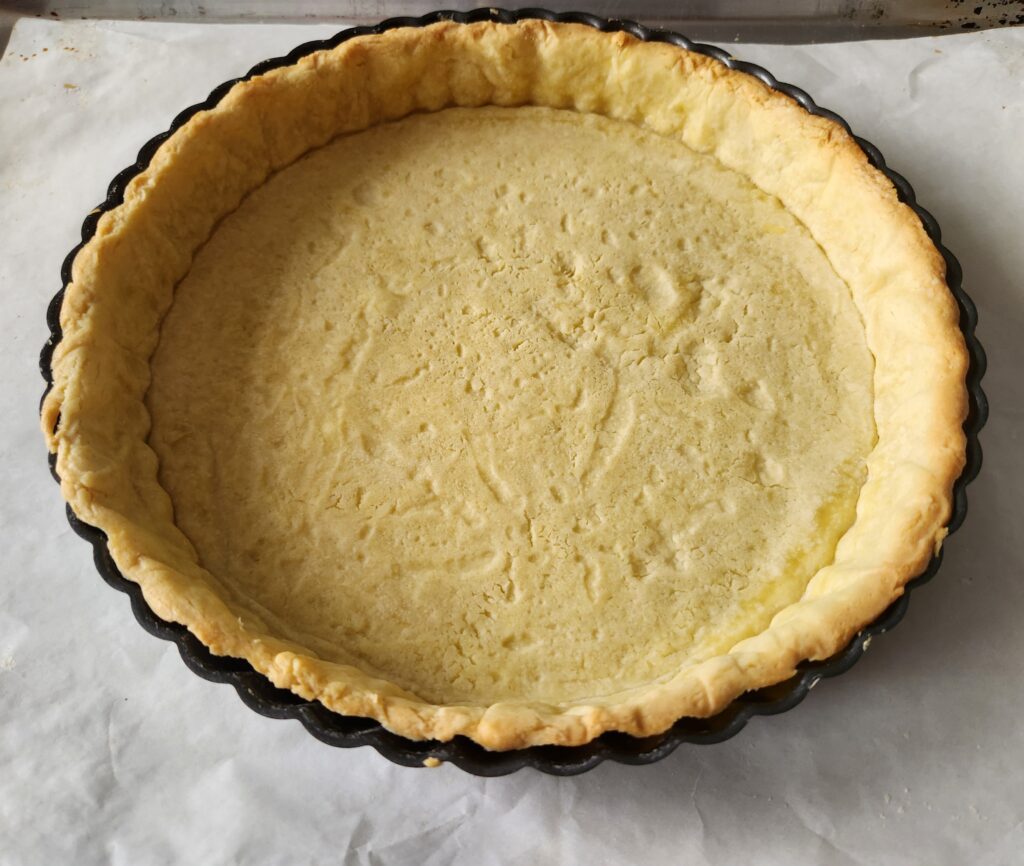 A pie crust sitting on top of wax paper.